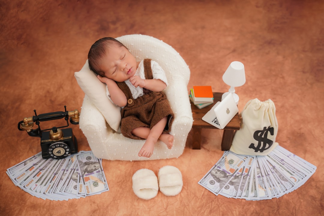 newborn-baby-sleeps-in-tiny-chair-with-money-props-hu7jsrkz6h4